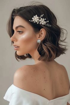 a woman wearing a bridal hair comb with flowers on it's head and shoulder