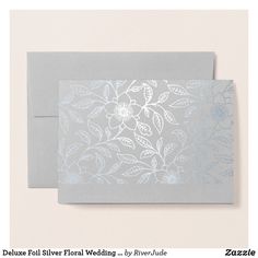 a close up of a wedding card on a white background with blue flowers and leaves