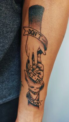 a man with a tattoo on his arm holding the hand of another person that is wearing a top hat