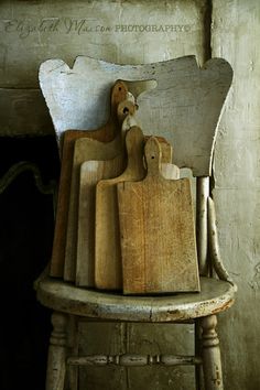 several wooden cutting boards sitting on top of a chair