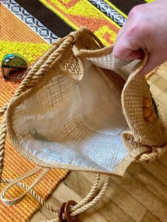 a hand holding a bag on top of a wooden floor