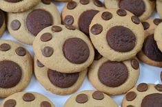 chocolate chip cookies are arranged in rows on a white plate, with one cookie shaped like a dog's paw