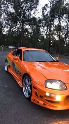 an orange sports car parked in a parking lot