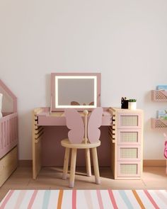 a child's bedroom with a pink desk and chair, striped rug and white walls