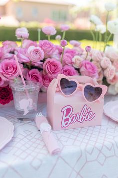 a table topped with pink flowers and glasses