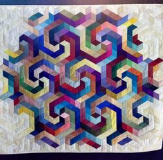 a quilted wall hanging with many different colors