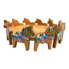 a wooden table and chairs with colorful designs on the back, set against a white background