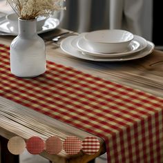 the table is set with plates and flowers in a white vase on top of it