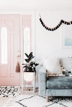 a living room filled with furniture and a pink door