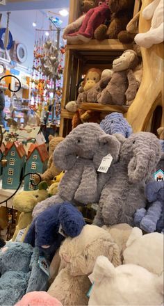 many stuffed animals are on display in a toy store, including one for the elephant