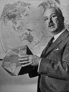 an old photo of a man in front of a world map holding a model of the earth