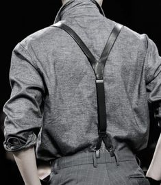 the back of a man's shirt and tie with suspenders on his shoulders