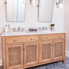 a bathroom with two sinks and mirrors on the wall next to a tiled flooring