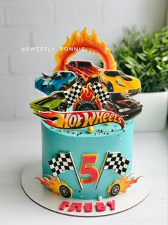 a birthday cake decorated with hot wheels and flames