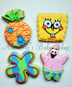 four decorated cookies on a white surface with one pineapple, the other an octopus