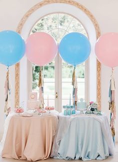 a table topped with balloons and cake next to an arch window at a wedding reception