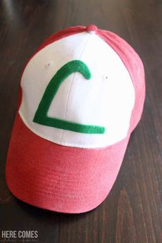 a red and white hat with a green logo on it sitting on top of a wooden table