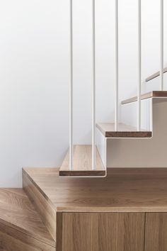 a white staircase with wooden handrails and wood flooring