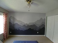 a bedroom with mountains painted on the wall