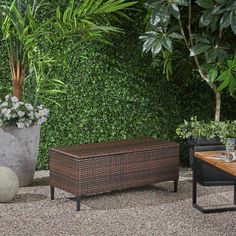 two planters and a table in front of a green wall