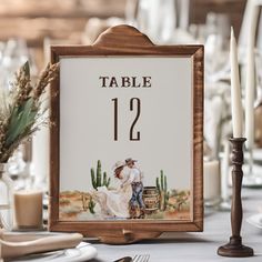 a table number sign with a painting of a bride and groom