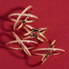 three different types of rings on a red surface, one with white stones and the other with diamonds