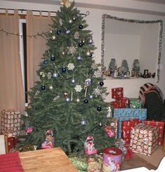 a small christmas tree with presents under it