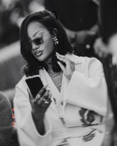 a black and white photo of a woman holding a cell phone in her right hand