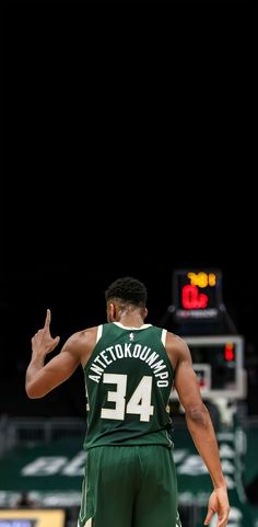 the basketball player is getting ready to make a play on the court with his hand up