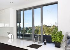 a kitchen with a sink, stove and large window