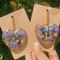 a pair of heart shaped earrings with pictures attached to the front and back of them