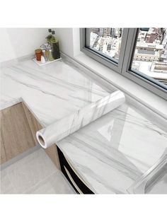 a white marble counter top next to a window