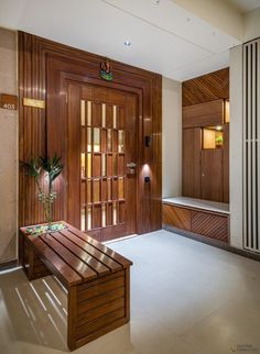 a wooden bench sitting in the middle of a room next to a wall with wood paneling