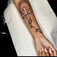 a woman's arm with a cross tattoo on it