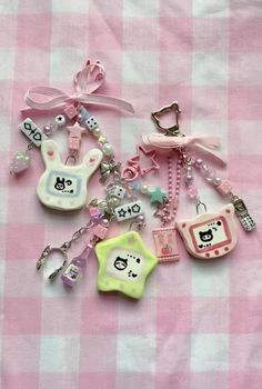 several different key chains on a pink and white checkered table cloth