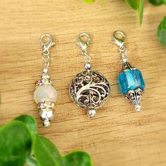 three charms sitting on top of a wooden table