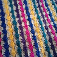 a crocheted blanket with multicolored stripes