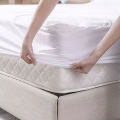 a person is pulling up the mattress on top of it's base and bottom