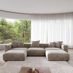 a living room with a large sectional couch and coffee table in front of the window