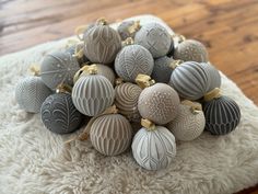 a pile of gray and white ornaments sitting on top of a wooden floor next to a rug