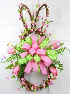 a wreath with pink and green bows hanging on the front door for $ 75 each