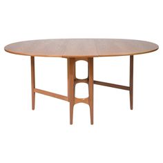 an oval wooden table with two leaves on the top and one leaf at the base