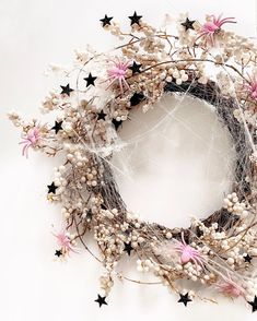 a white wreath with black and pink stars on it sitting on top of a table