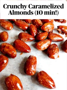 almonds are scattered on a sheet of parchment paper and ready to be cooked in the oven