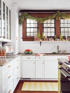 a kitchen with white cabinets and christmas decorations