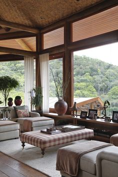 a living room filled with lots of furniture next to a large window covered in wood