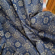 a blue and white patterned fabric on a wooden chair