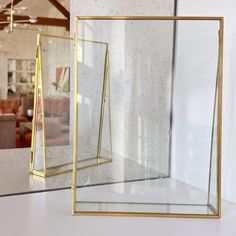 two glass cases sitting next to each other on a white counter top in front of a window