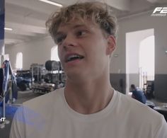 a young man in a gym looking at the camera