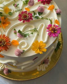 a cake decorated with flowers and icing on a gold plate